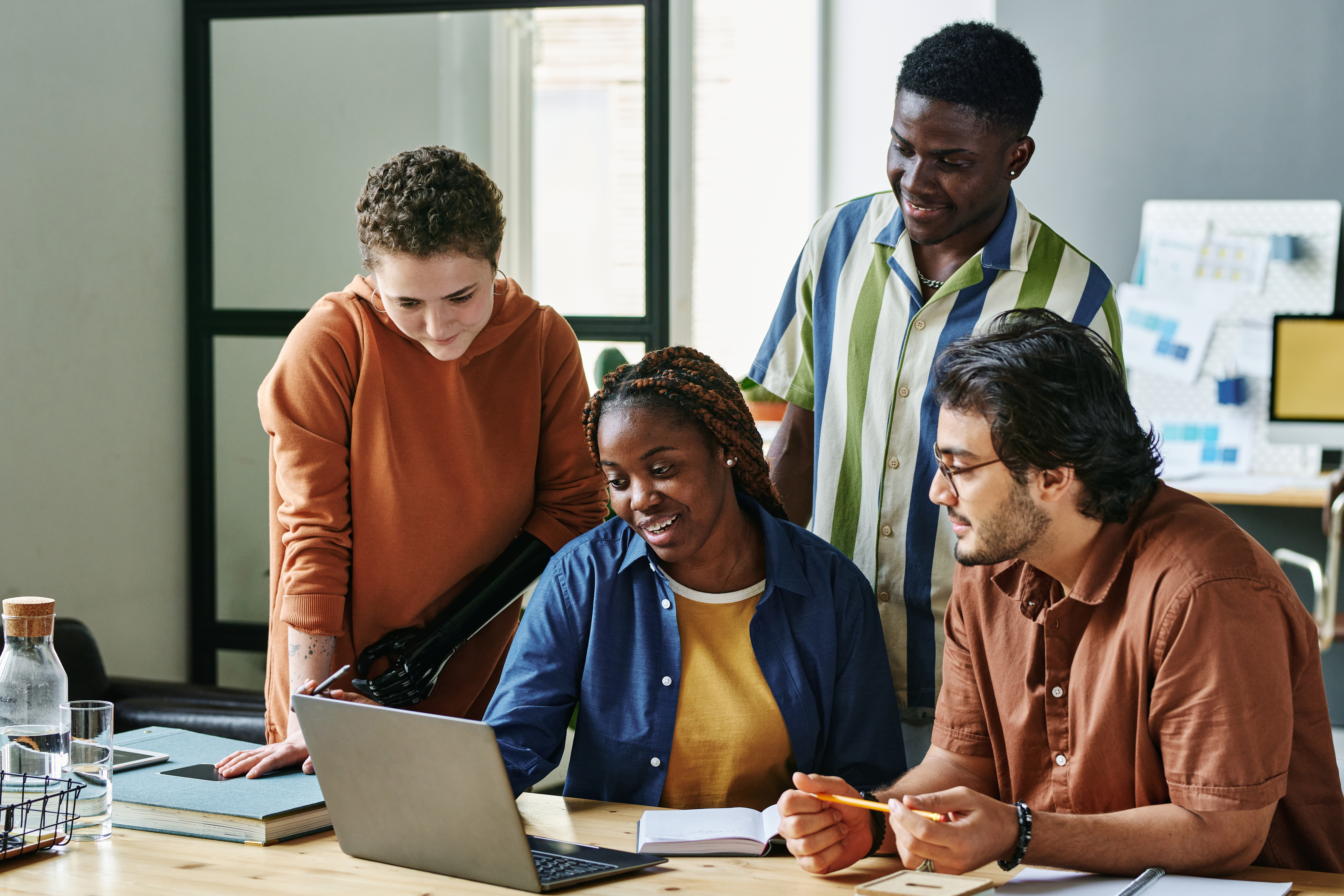 Group of intercultural employees listening to young African American female colleague making report or presentation at meeting